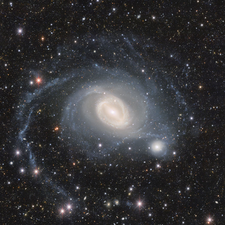 NOIRLab image of region near spiral galaxy NGC 1512, enhanced to show off its fainter features, and also showing NGC 1510