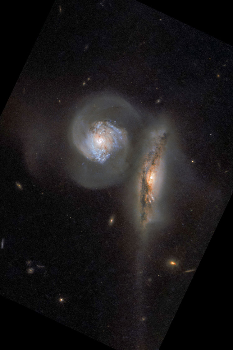 HST image of the pair of interacting spiral galaxies listed as NGC 5765, also showing part of their extended tails